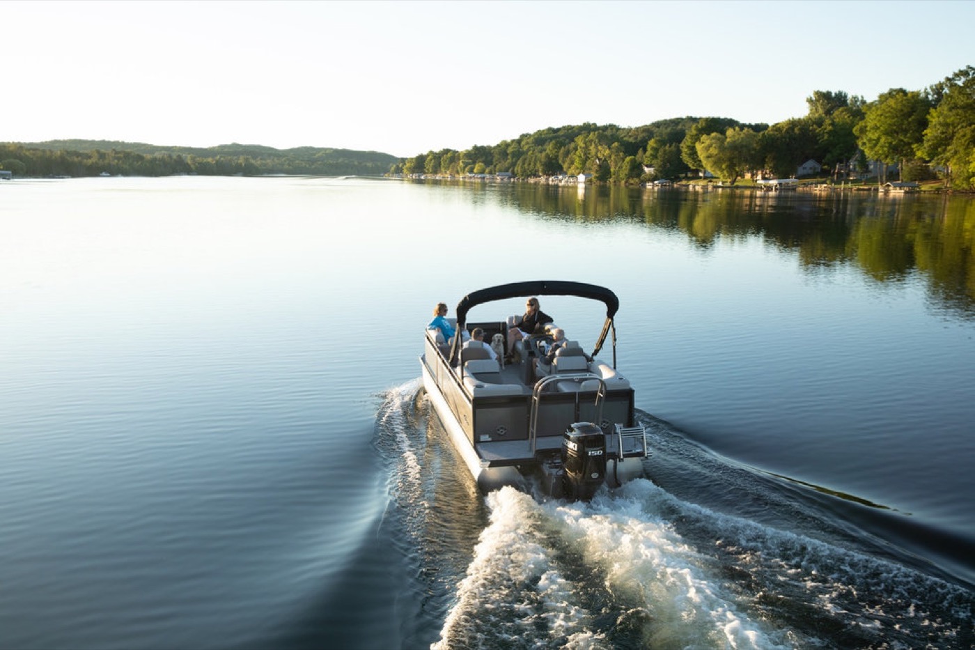 A pontoon cruising across calm lake water